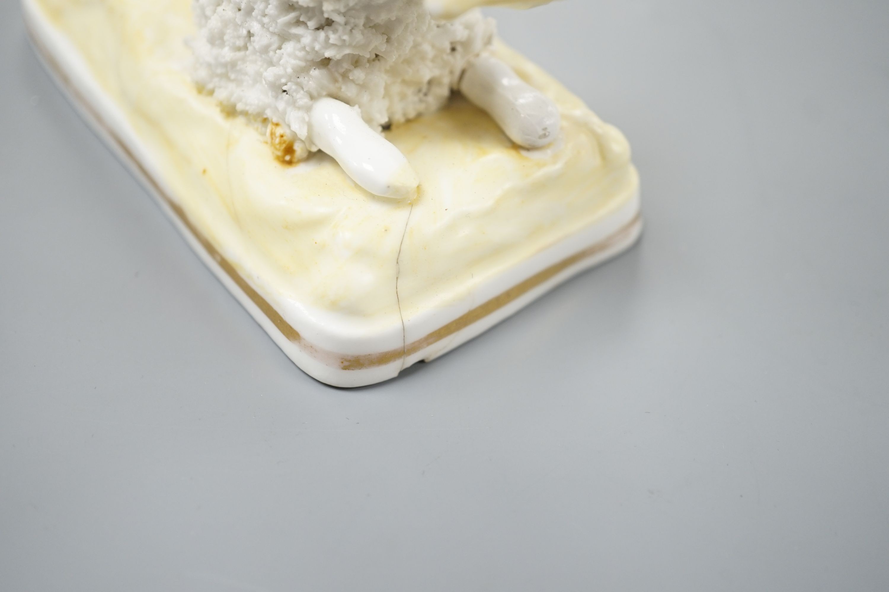 A Samuel Alcock model of a poodle grasping a bone, c.1835–50, 11.1 cm long, Cf. Dennis G.Rice Dogs in English porcelain, colour plate 64., Provenance: Dennis G.Rice collection